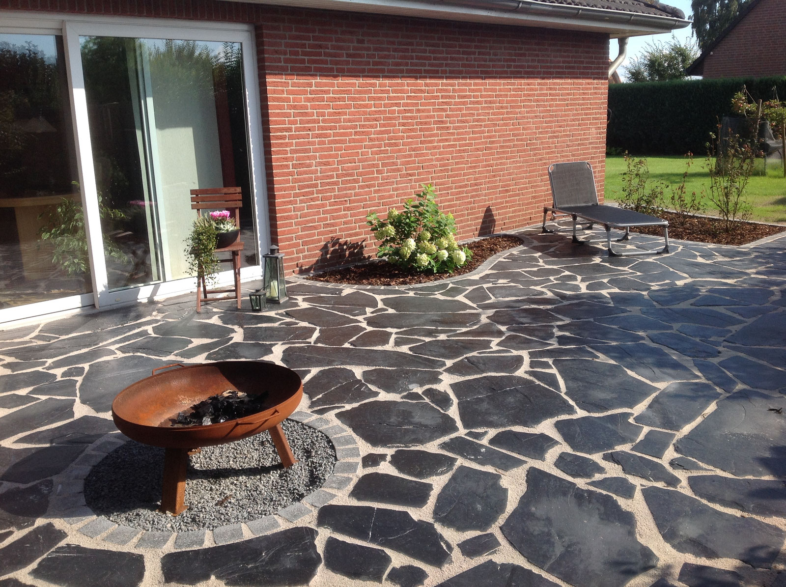 Naturstein-Terrasse mit Feuerschale als Garten- und Landschaftsbau