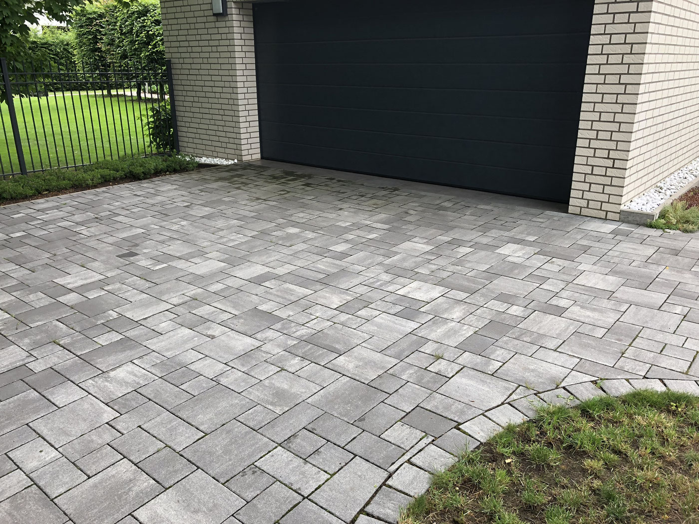 Fertig gepflasterte Hofeinfahrt aus grauem Pflasterstein